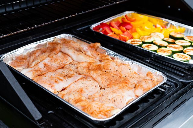 tray of chicken and tray of vegetables in the over